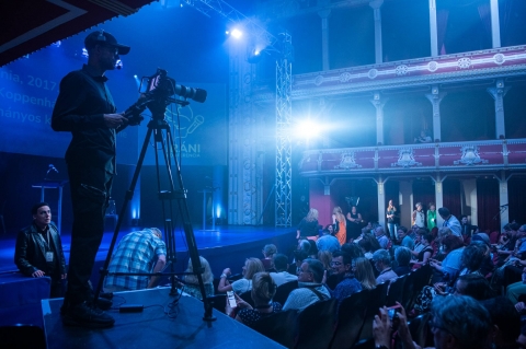 Az Iráni konferencia kapta a legjobb rendezés díját - Az Iráni konferencia kapta a legjobb rendezés díját
Az idén Kaposváron tartott Országos Színházi Találkozó (OSZT) díjait tegnap este adták át a helyi Csiky Gergely Színházban. A zsűri döntése alapján a június 10–16. között a somogyi vármegyeszékhelyen tartott seregszemle legjobb rendezés díját Bocsárdi László kapta a sepsiszentgyörgyi Tamási Áron Színház Iráni konferencia című előadásának színre viteléért.
Bocsárdi László jelenleg éppen Temesváron rendez, nem lehetett jelen a díjkiosztó gálán, ezért videóüzenetben köszönte meg a rangos elismerést a fesztivál válogatóinak és zsűrijének egyaránt. Mint fogalmazott, az egész alkotócsapat számára nagy megtiszteltetés ez a díj, és mindenkinek gratulálni szeretne hozzá, elsősorban Ivan Viripajevnek a dráma megírásáért. „Remélem, hogy az Országos Színházi Találkozó idei kiadása szerencsés kezdete egy olyan fesztivál létrejöttének, amely méltó módon képviseli a magyarországi színházi szakmát” – fogalmazott Bocsárdi László üzenetében.
Az Országos Színházi Találkozóra idén 65 társulat 107 előadással jelentkezett, a válogatók által ajánlott 10 nagyszínpadi és 10 kamaraszínházi előadásból a Csiky Gergely Színház művészeti tanácsa 14 darabot választott ki, amelyet a Kritikusok Céhe által jelölt 2 független előadás egészített ki. A közönséget a versenyprogramban szereplő 16 előadás mellett számos off-programra, köztük színházi és táncelőadásokra, családi és gasztronómiai programokra, koncertekre is várták Kaposváron.